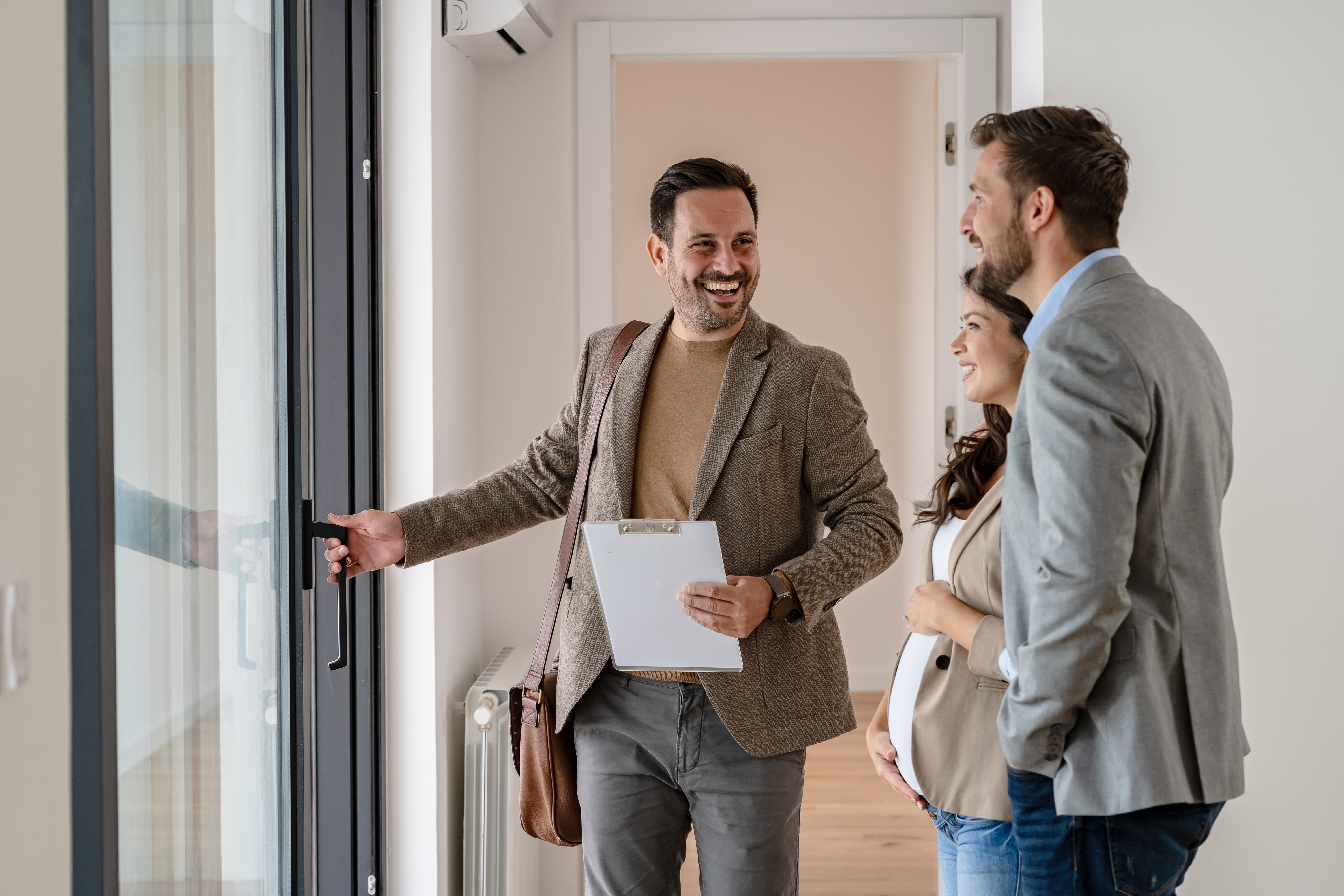 A young couple tour a home for sale with a realtor